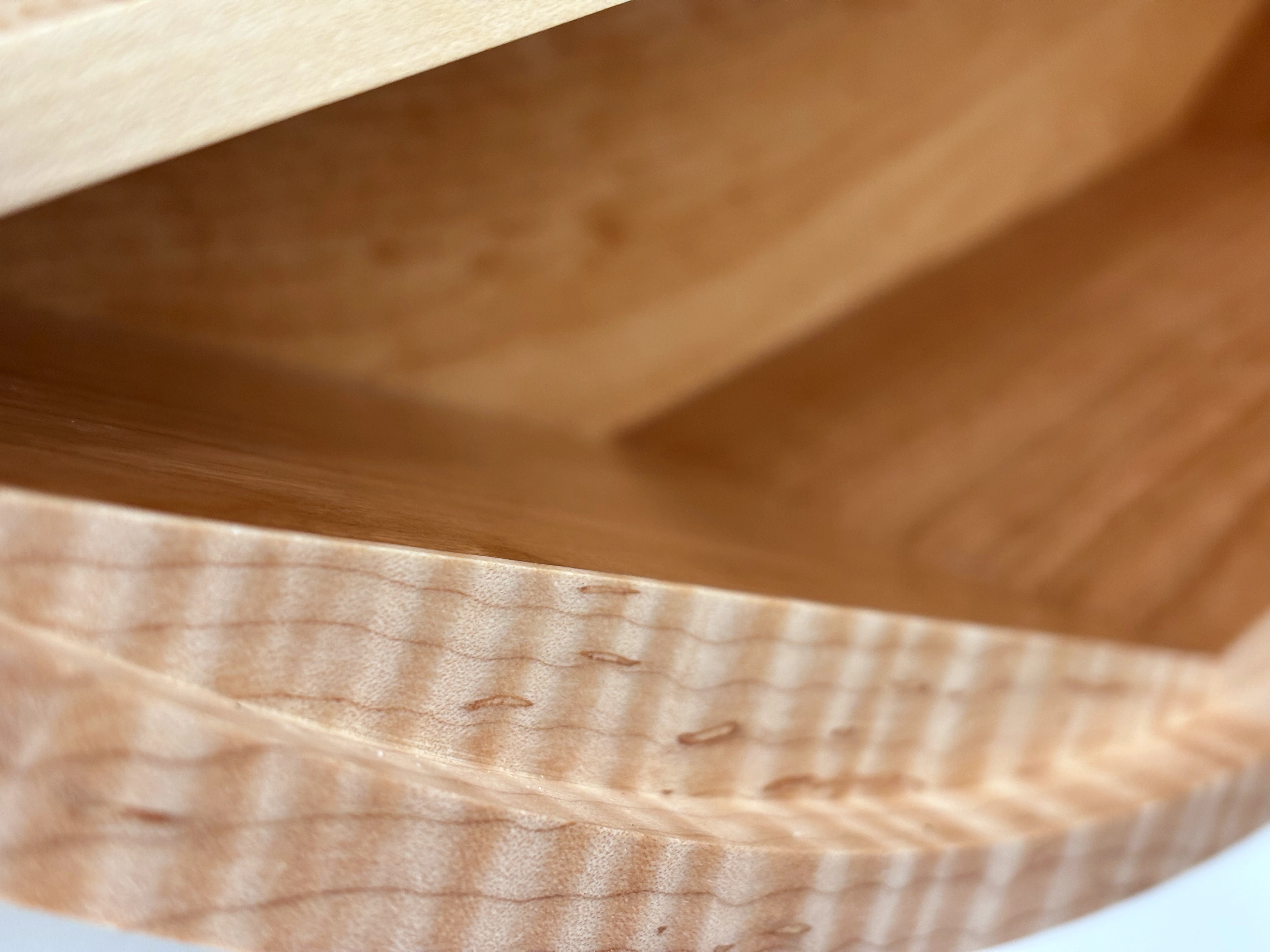 Close-up of carved Roman numeral detail on handmade hardwood wall clock